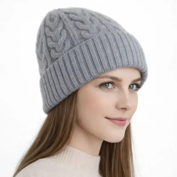 Bonnet d’hiver pour femme en laine grise, présenté en vue trois-quarts, avec tricot torsadé.