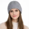 Femme portant un bonnet tricoté gris avec revers large, style chic et décontracté pour les jours froids.