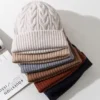 Pile de bonnets pour femme en maille épaisse, disponibles en plusieurs couleurs automne-hiver.