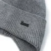 Détail de la maille d’un bonnet homme avec cache oreilles et logo discret, texture épaisse pour l’hiver