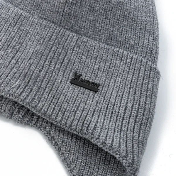 Détail de la maille d’un bonnet homme avec cache oreilles et logo discret, texture épaisse pour l’hiver